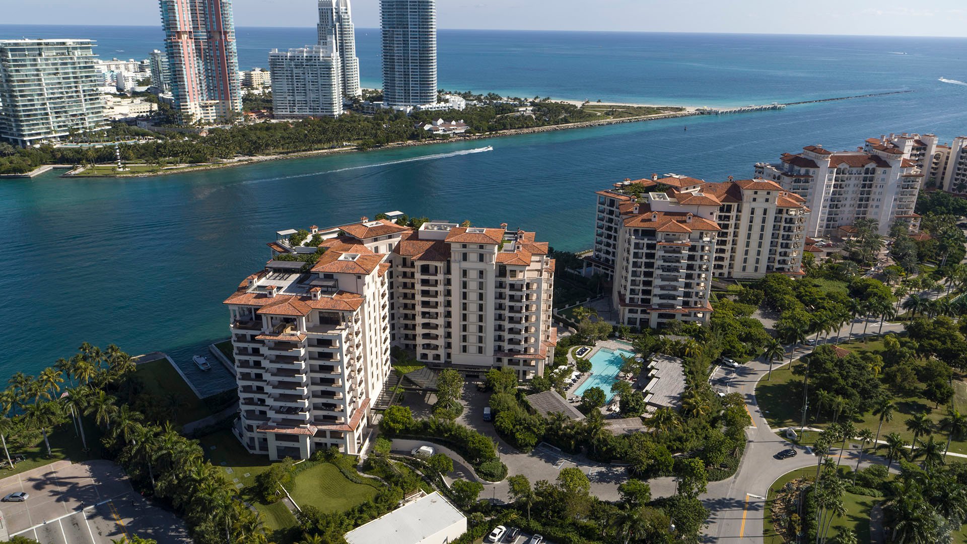 Palazzo della Luna in Fisher Island luxury and ultra luxury condos in an aerial waterfront view with neighboring towers, marina water, and the city skyline.