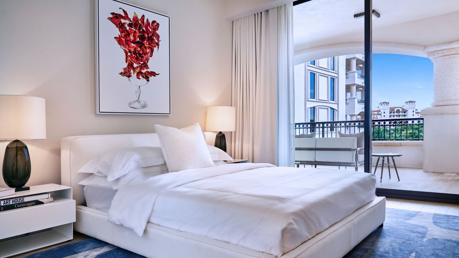 Palazzo della Luna in Fisher Island luxury and ultra luxury condos with a bedroom, framed artwork, and an arched terrace opening to the exterior view.