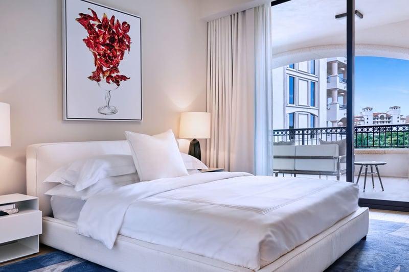 Palazzo della Luna in Fisher Island luxury and ultra luxury condos with a bedroom, framed artwork, and an arched terrace opening to the exterior view.