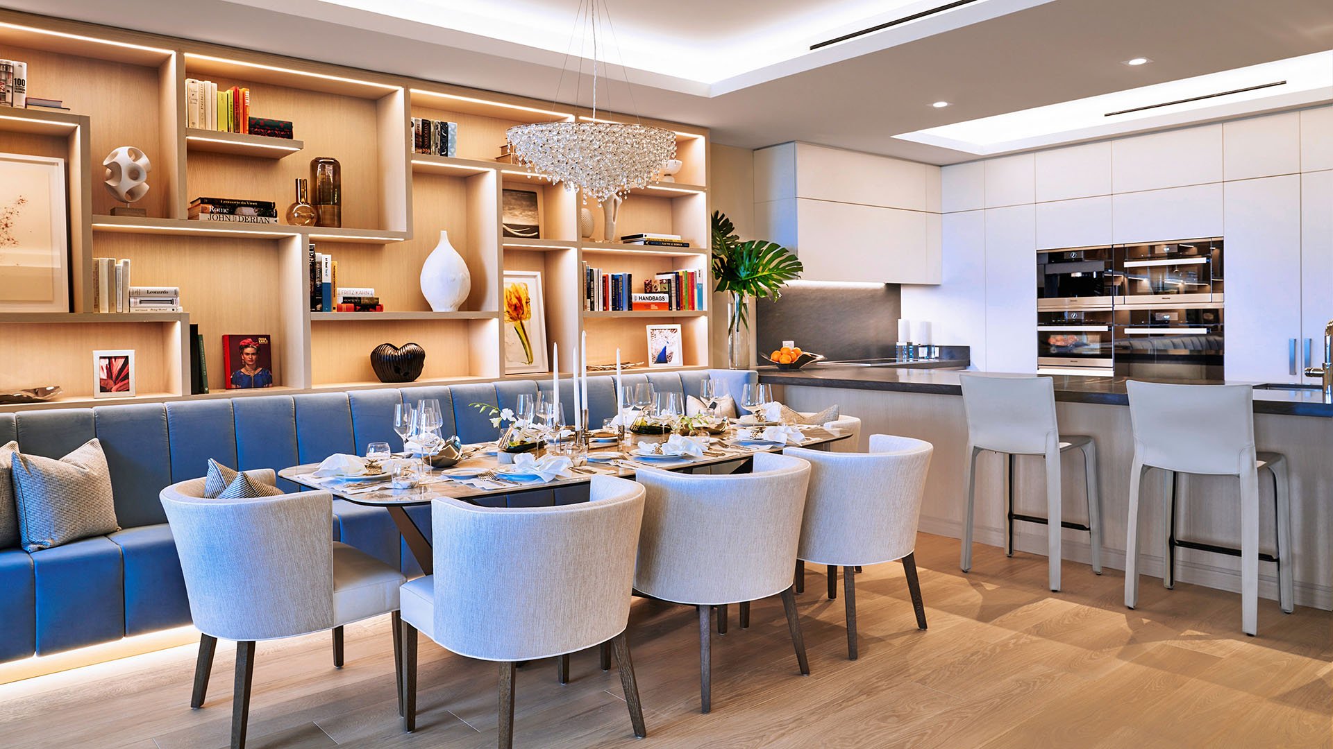 Palazzo della Luna in Fisher Island luxury and ultra luxury condos with a chef kitchen island, dining room seating, built-in cabinetry, and warm wood floors.