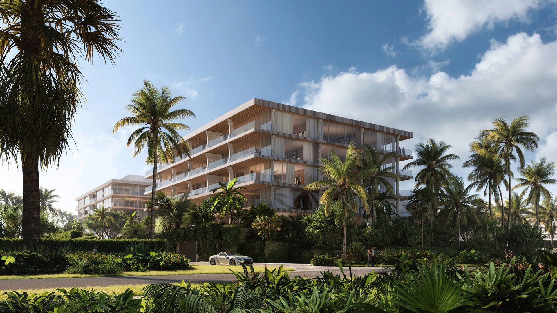 Palm Beach Residences by Aman, Palm Beach, Florida, modern beachfront condo exterior framed by lush gardens and palm trees with private drive, promoting luxury and ultra luxury preconstruction condos in a tropical setting.