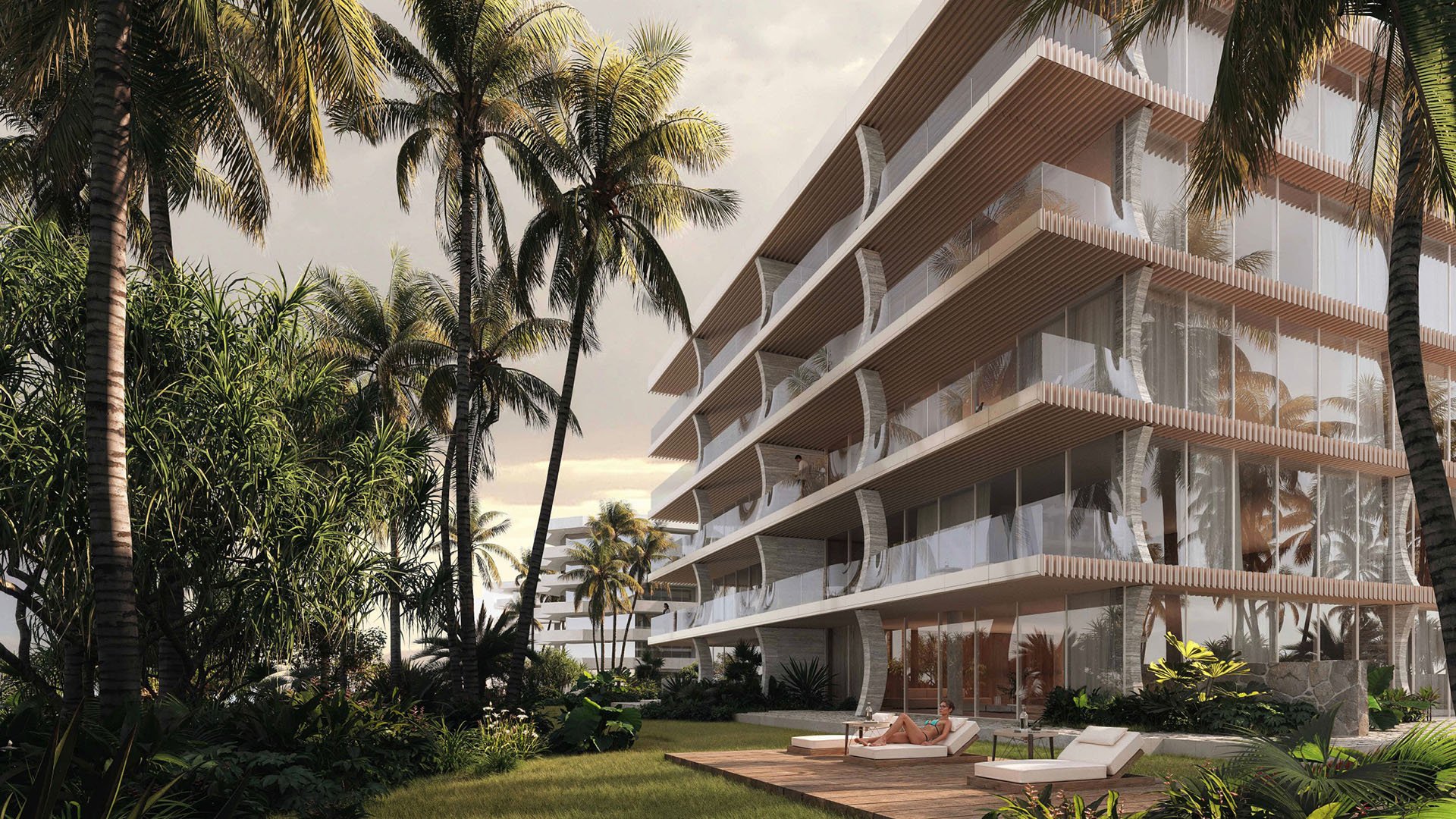 Palm Beach Residences by Aman in Palm Beach, Florida, resort-style grounds with palms, glass-fronted residences and sun deck lounge, highlighting luxury and ultra luxury preconstruction condos with serene tropical landscaping.