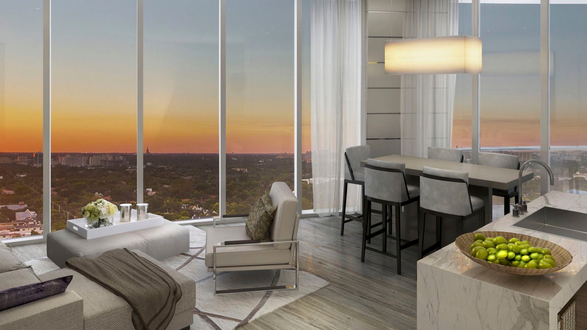 Compact living room with a kitchen island, dining nook and sunset skyline view at Park Grove in Coconut Grove, illustrating efficient luxury and ultra luxury condos interiors.
