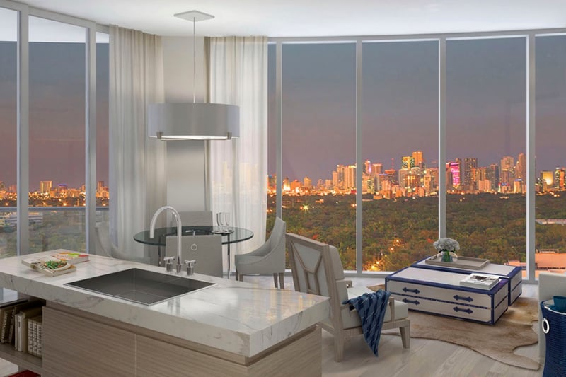 Kitchen island great room with a city skyline at dusk, floor-to-ceiling glass and lounge seating at Park Grove in Coconut Grove, defining luxury and ultra luxury condos living.