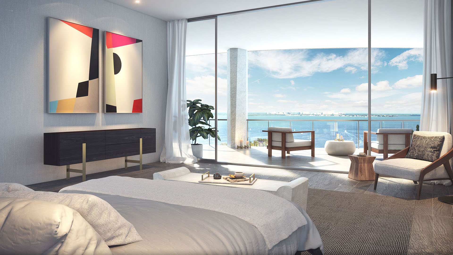 Primary bedroom with abstract wall art, lounge seating and an open bay view terrace at Park Grove in Coconut Grove, tailored to luxury and ultra luxury condos living.