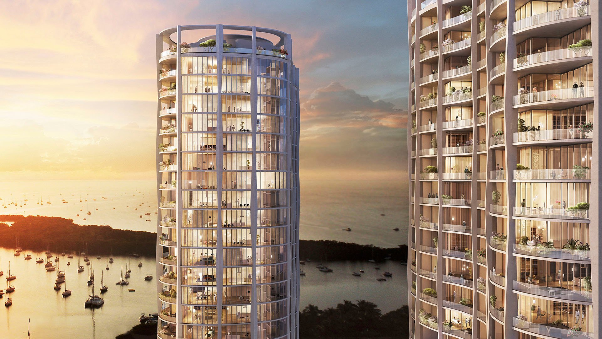 Twin curved condo towers glowing at sunset above the waterfront at Park Grove in Coconut Grove, revealing the landmark architecture of the luxury and ultra luxury condos.