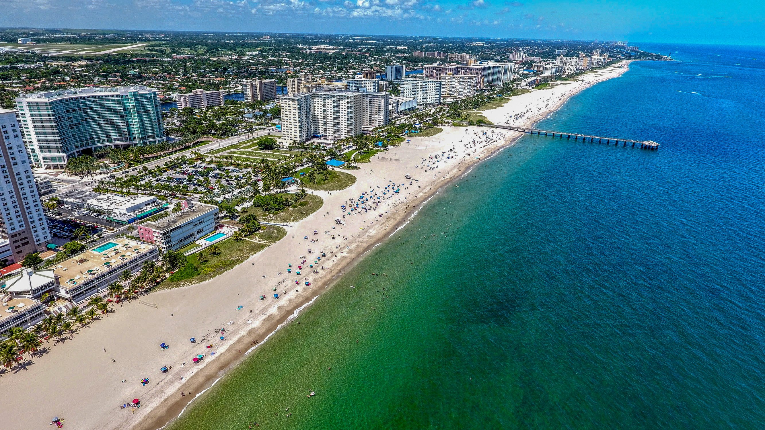 Pompano Beach, Florida sunny beachfront aerial with turquoise water and towers—prime market for luxury and ultra luxury condos, offering preconstruction and resale.