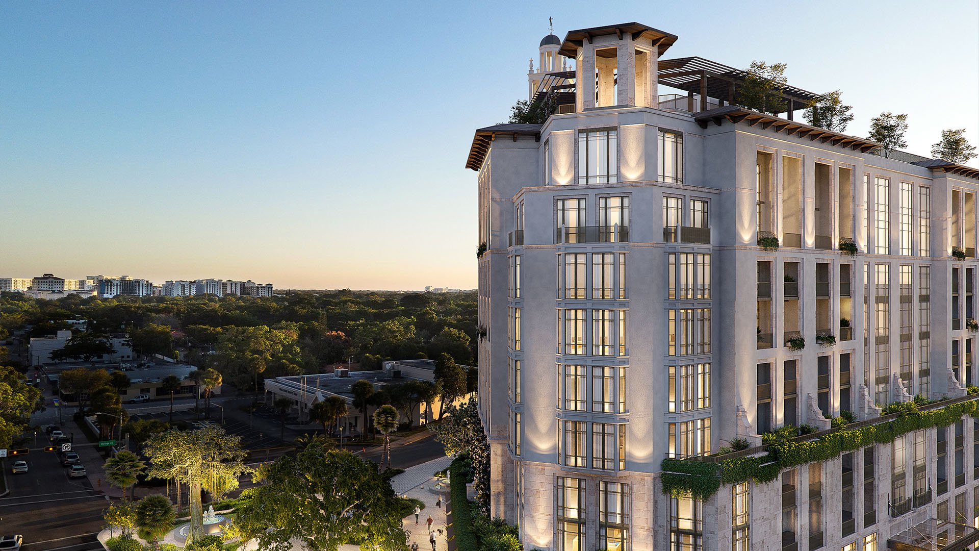 Ponce Park Residences in Coral Gables, Miami aerial corner view at golden hour with rooftop terraces and skyline backdrop, showcasing luxury and ultra luxury preconstruction condos with elegant illuminated facade.