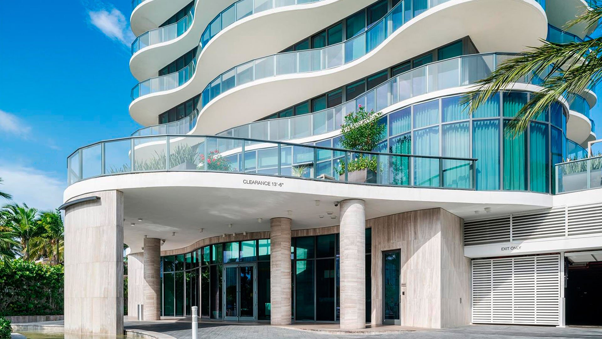 Main entrance at Regalia in Sunny Isles Beach showing the curved porte cochere and glass facade of luxury and ultra luxury condos.