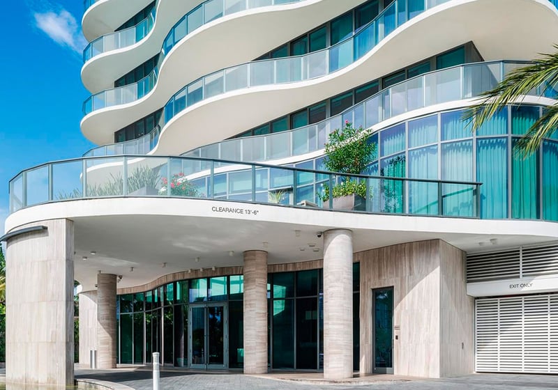 Main entrance at Regalia in Sunny Isles Beach showing the curved porte cochere and glass facade of luxury and ultra luxury condos.