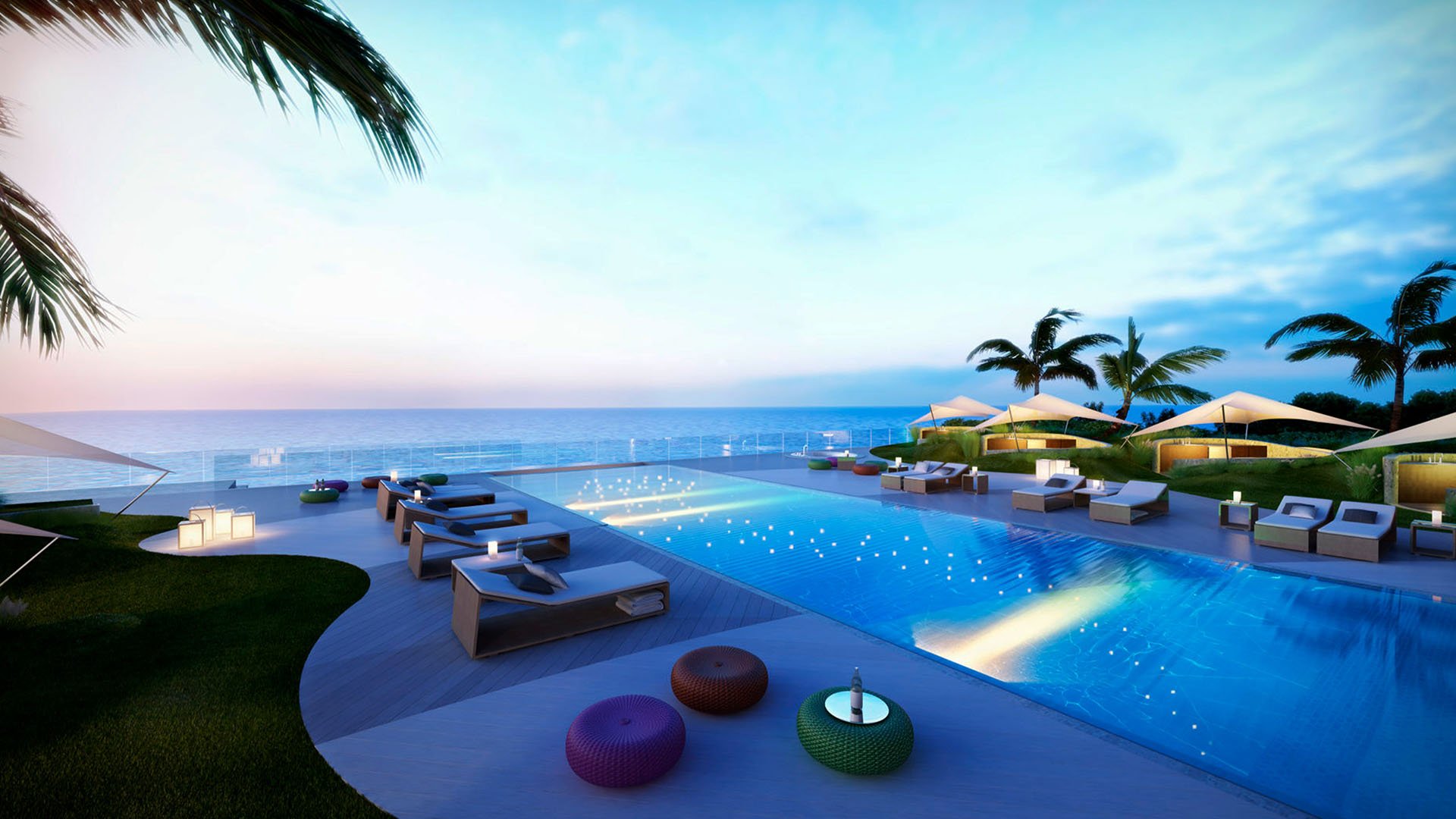 Evening infinity pool deck at Regalia in Sunny Isles Beach with loungers, palms, and a glowing waterside terrace for luxury and ultra luxury condos.