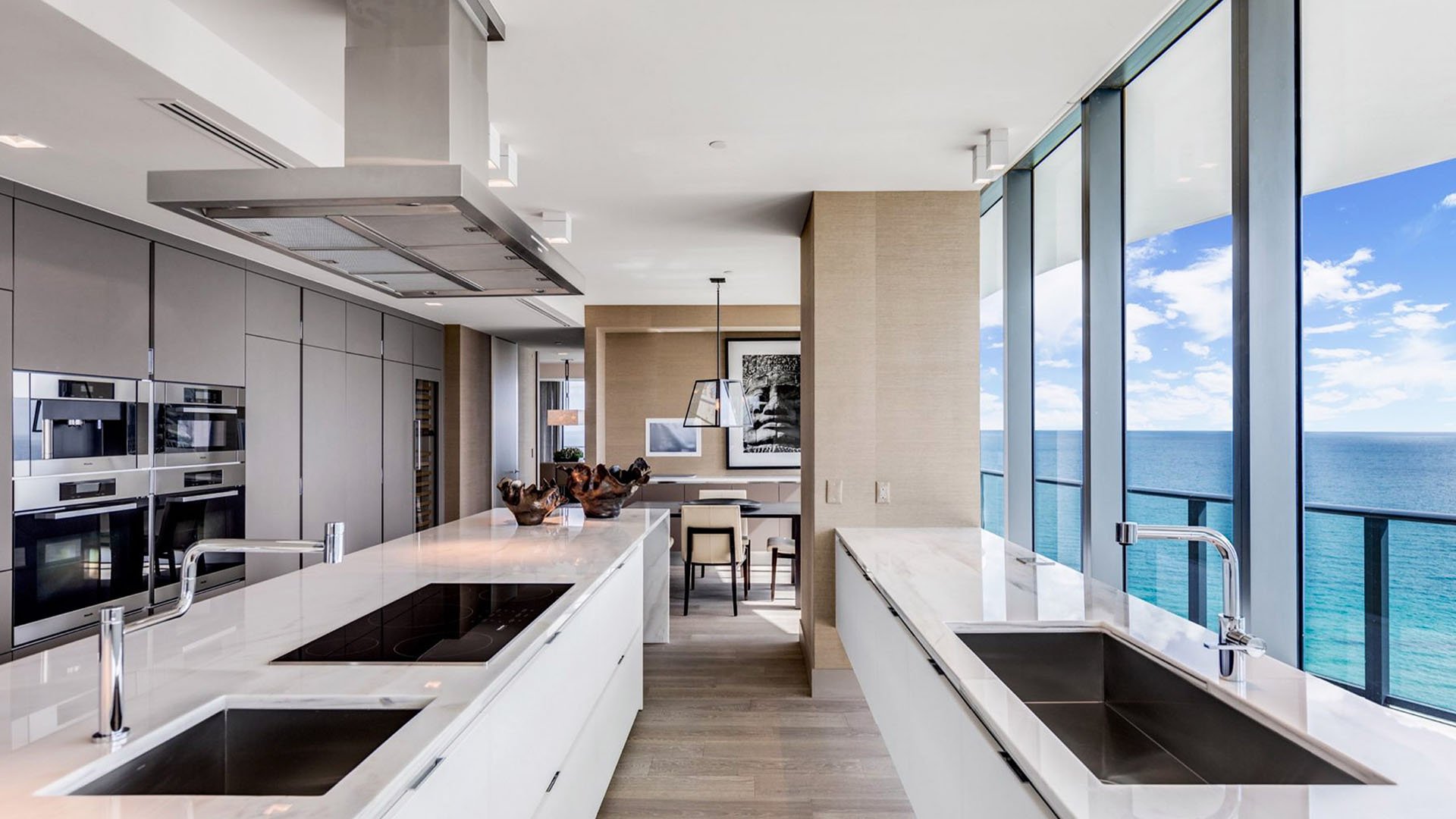 Galley chef kitchen at Regalia in Sunny Isles Beach with ocean-view windows, long counters, and integrated appliances inside luxury and ultra luxury condos.