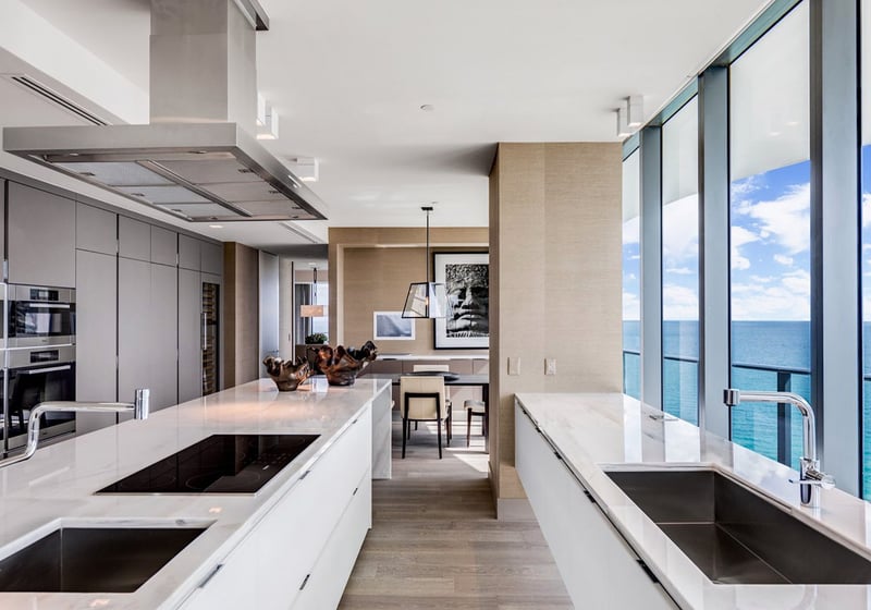 Galley chef kitchen at Regalia in Sunny Isles Beach with ocean-view windows, long counters, and integrated appliances inside luxury and ultra luxury condos.