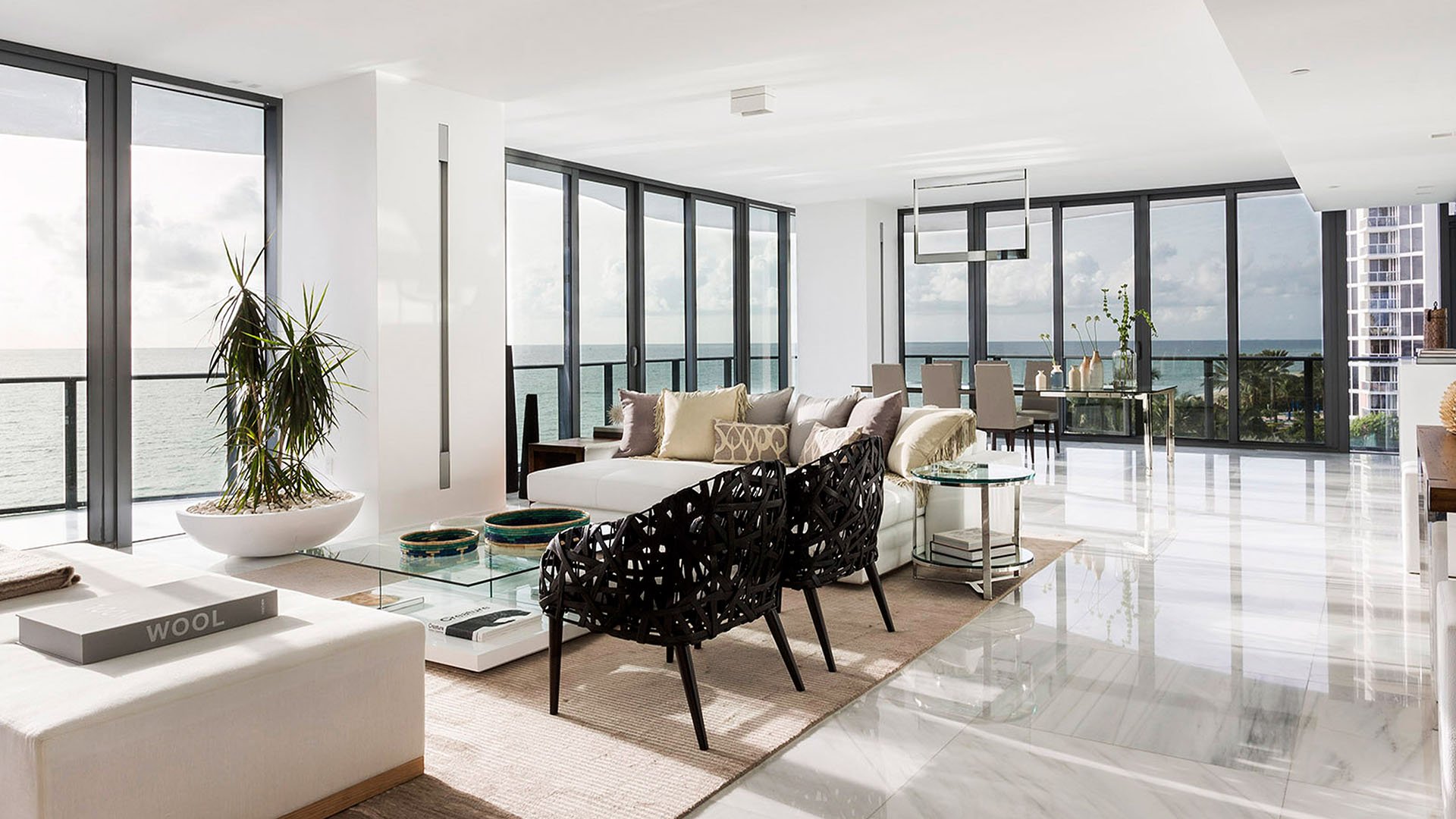 Open-plan living and dining area at Regalia in Sunny Isles Beach with glossy marble floors and wraparound water views in luxury and ultra luxury condos.