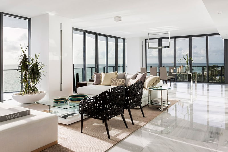 Open-plan living and dining area at Regalia in Sunny Isles Beach with glossy marble floors and wraparound water views in luxury and ultra luxury condos.
