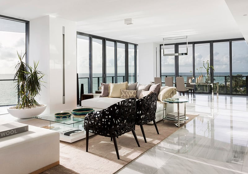 Open-plan living and dining area at Regalia in Sunny Isles Beach with glossy marble floors and wraparound water views in luxury and ultra luxury condos.