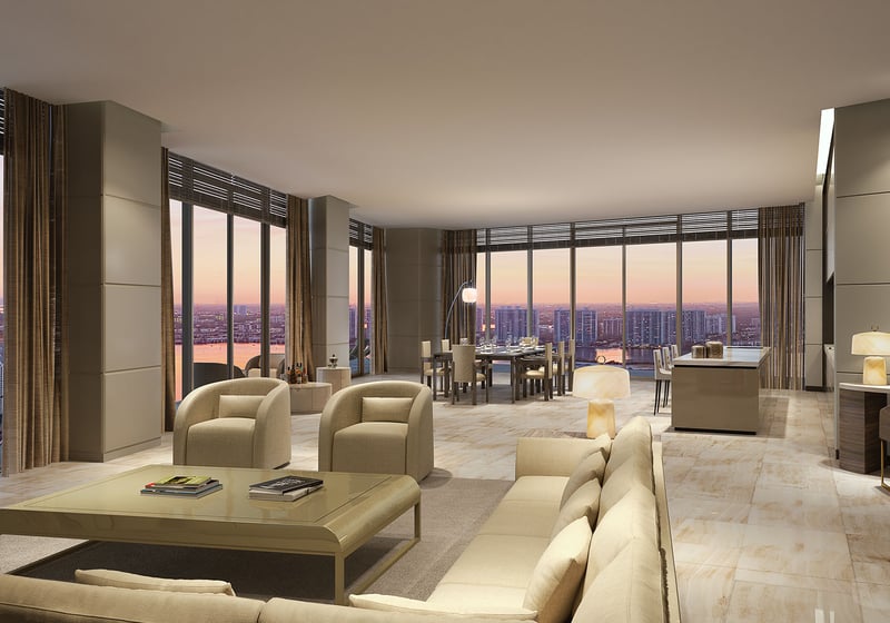 Residences by Armani Casa, Sunny Isles Beach luxury and ultra luxury preconstruction condos, corner living room with sectional seating, dining area, and sunset skyline views through wraparound glass.