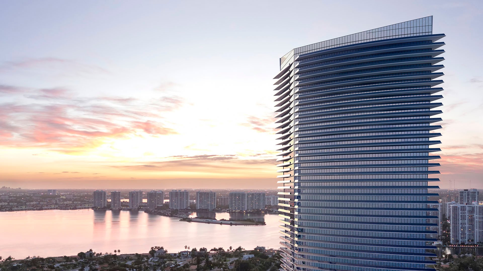 Residences by Armani Casa, Sunny Isles Beach luxury and ultra luxury preconstruction condos, sunset exterior of the sculpted tower with waterfront skyline views and glowing bands of glass balconies.