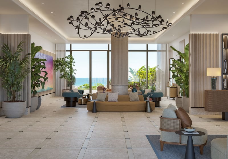 Lobby lounge at Rosewood Residences Hillsboro Beach, Florida with sculptural chandelier, designer seating and Atlantic Ocean view, defining luxury and ultra luxury preconstruction condos lifestyle.