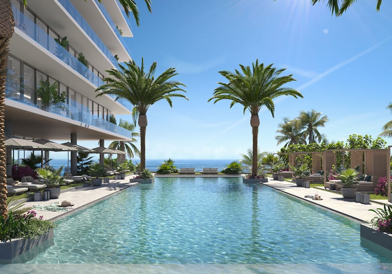 Rosewood Residences Hillsboro Beach, Florida resort-style pool deck with palms, loungers and direct Atlantic Ocean views, amenities for luxury and ultra luxury preconstruction condos.