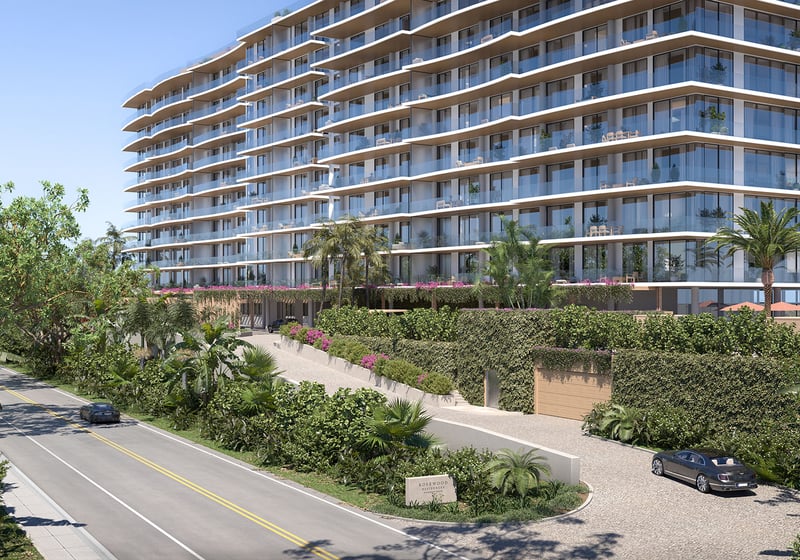 Rosewood Residences Hillsboro Beach, Florida street-view exterior with glass balconies, lush tropical landscaping and arrival driveway, showcasing luxury and ultra luxury preconstruction condos.