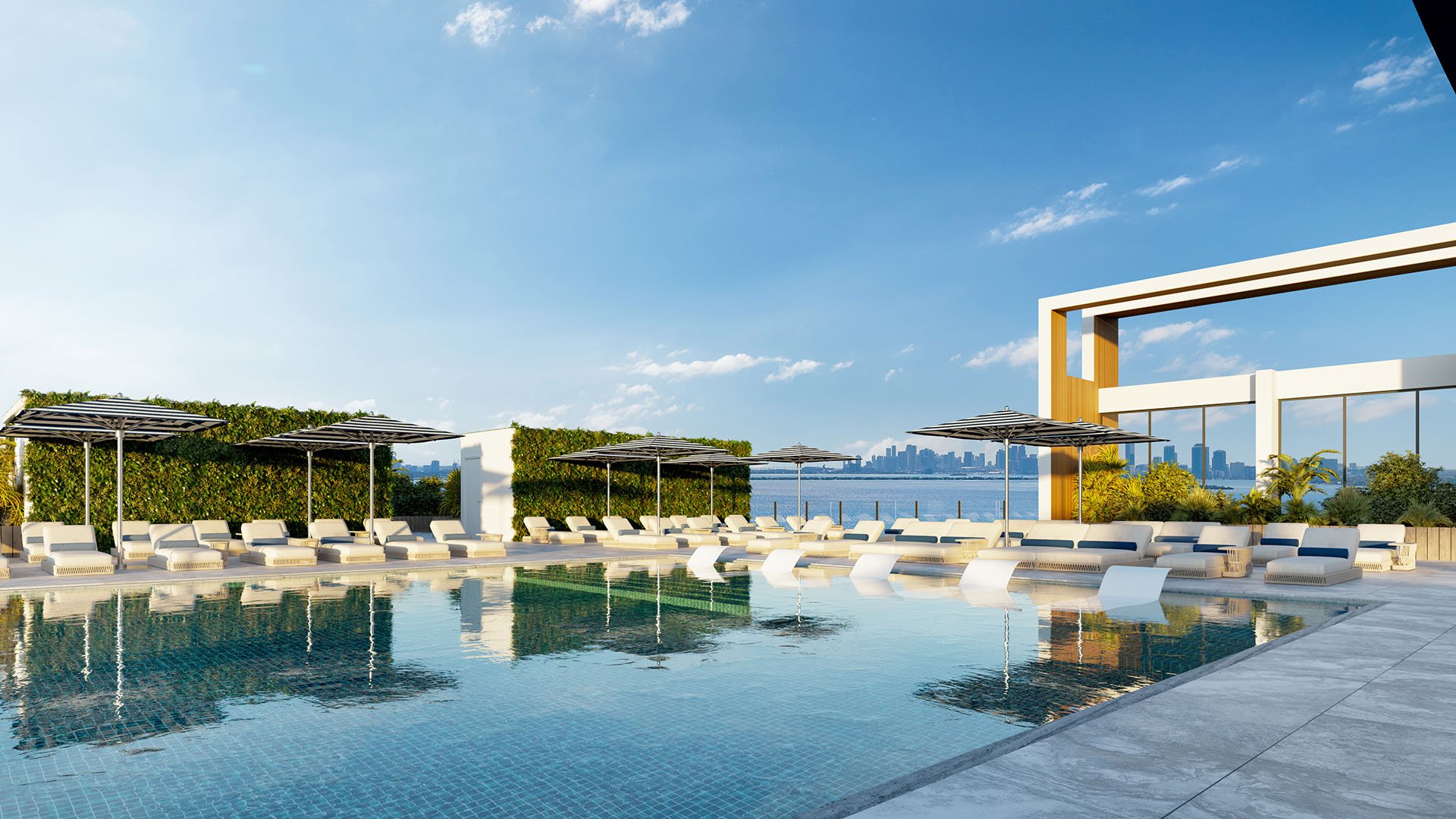 Shoma Bay North Bay Village rooftop pool deck with modern architectural frame, shaded loungers and Biscayne Bay views toward Miami skyline, featuring luxury and ultra luxury preconstruction condos resort amenities.