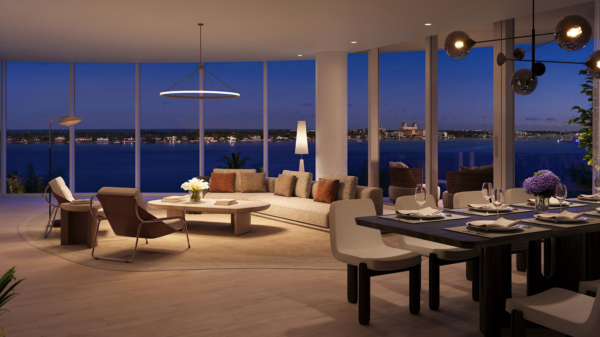 Shorecrest Flagler Drive living and dining room at night in West Palm Beach, Florida, with panoramic waterfront views and designer lighting - luxury, ultra luxury preconstruction condos modern interior.