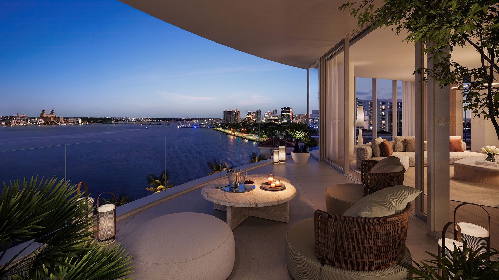 Shorecrest Flagler Drive, West Palm Beach, Florida private terrace balcony with cushioned lounge seating and waterfront night skyline, highlighting luxury and ultra luxury preconstruction condos views.