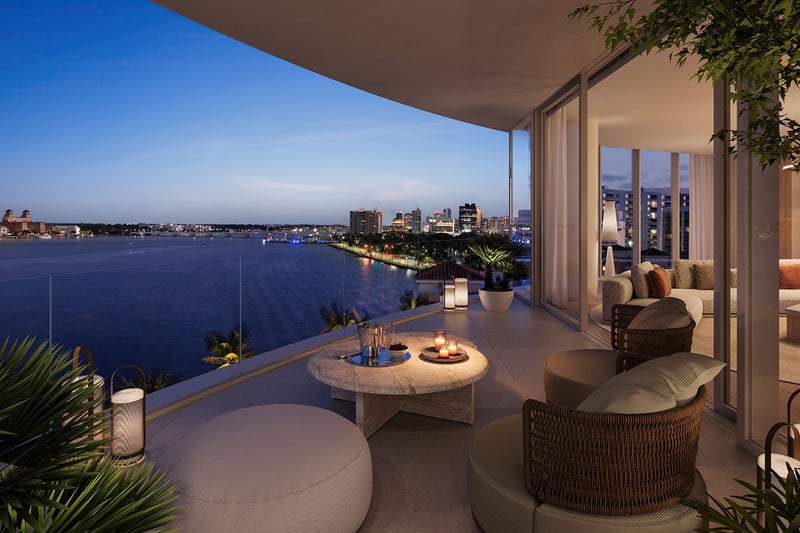 Shorecrest Flagler Drive, West Palm Beach, Florida private terrace balcony with cushioned lounge seating and waterfront night skyline, highlighting luxury and ultra luxury preconstruction condos views.
