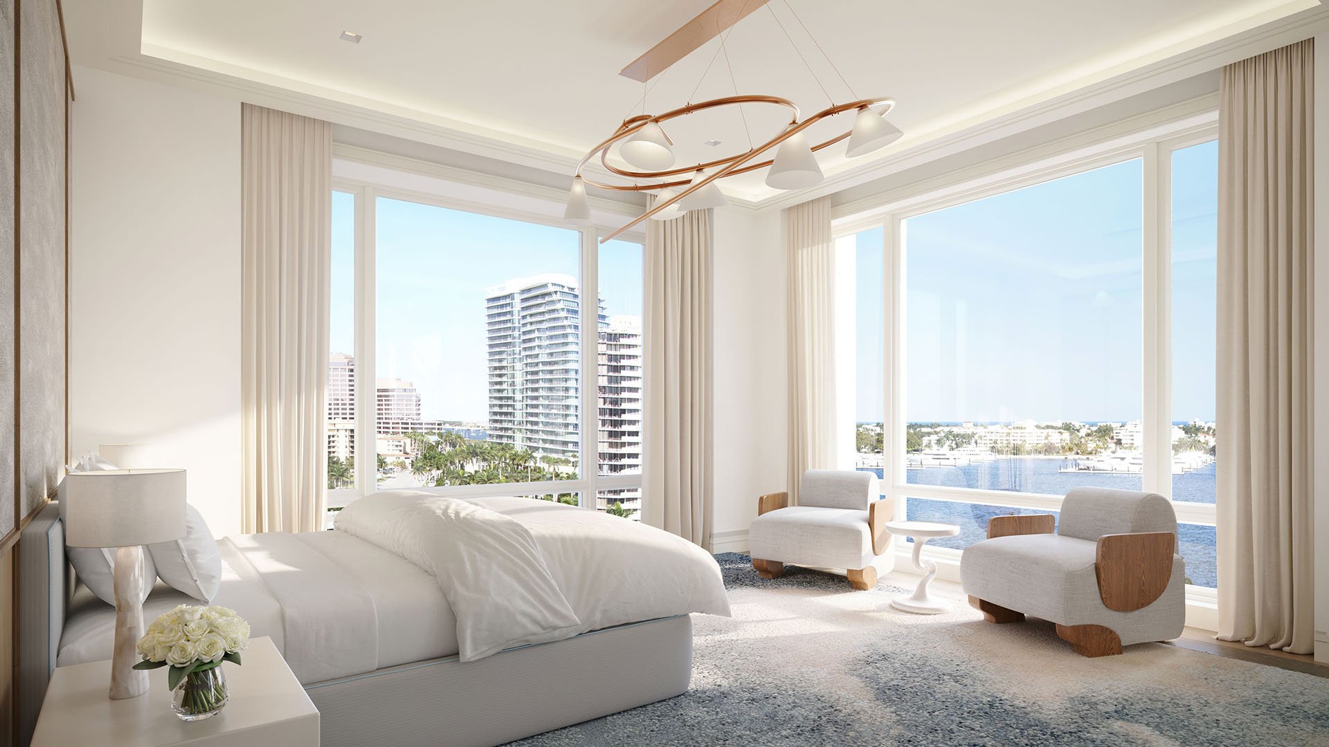 Bedroom with corner windows, lounge chairs and a wide waterfront view at South Flagler House in West Palm Beach, showcasing luxury and ultra luxury condos with a serene, light-filled interior.