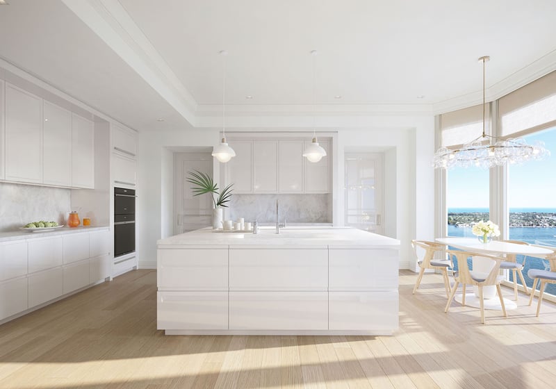 Chef kitchen with an oversized island, breakfast area and broad water views at South Flagler House in West Palm Beach, highlighting luxury and ultra luxury condos with bright contemporary finishes.