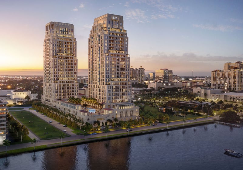 Twilight aerial view of the twin waterfront towers at South Flagler House in West Palm Beach, highlighting luxury and ultra luxury condos with illuminated architecture along the shoreline.