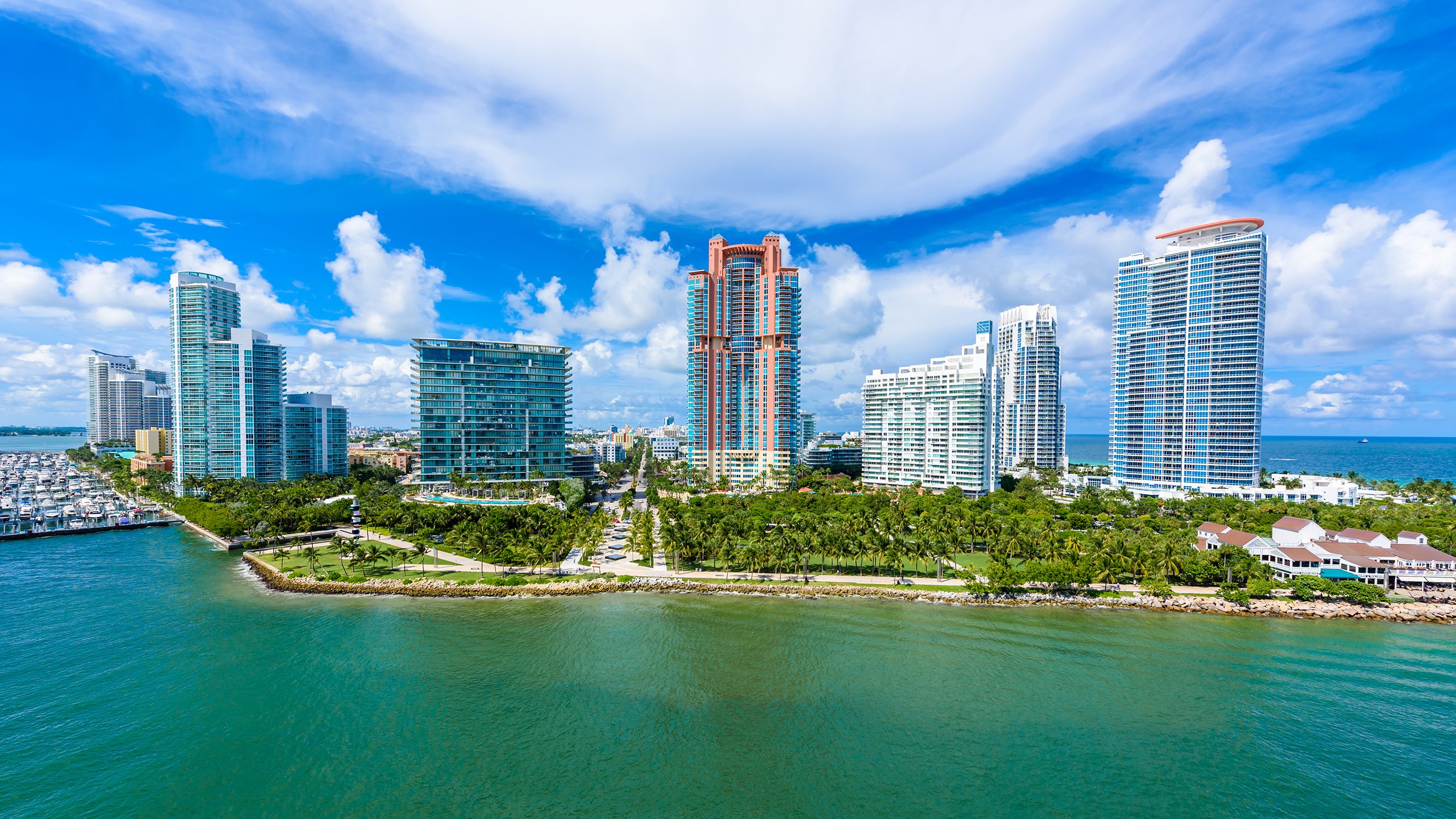 South of Fifth, Miami Beach waterfront marina with high‑rises and boardwalk, prime area for luxury and ultra luxury condos; preconstruction and resale. Featuring skyline.