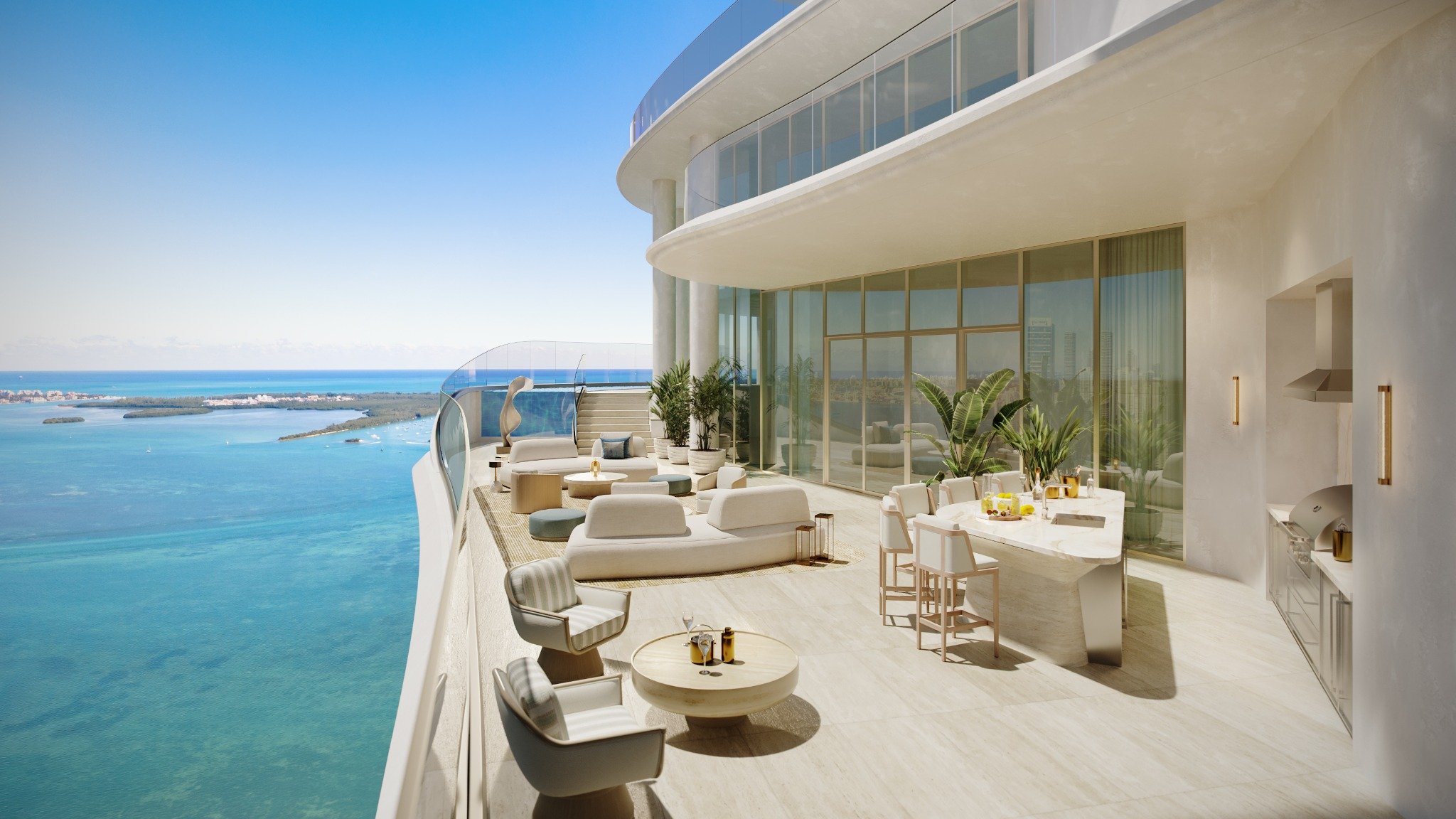 Curved waterfront penthouse terrace with outdoor lounge seating, dining island, summer kitchen, floor-to-ceiling glass, and expansive bay views at St Regis Residences Miami in Brickell, showcasing ultra luxury and exclusive living.