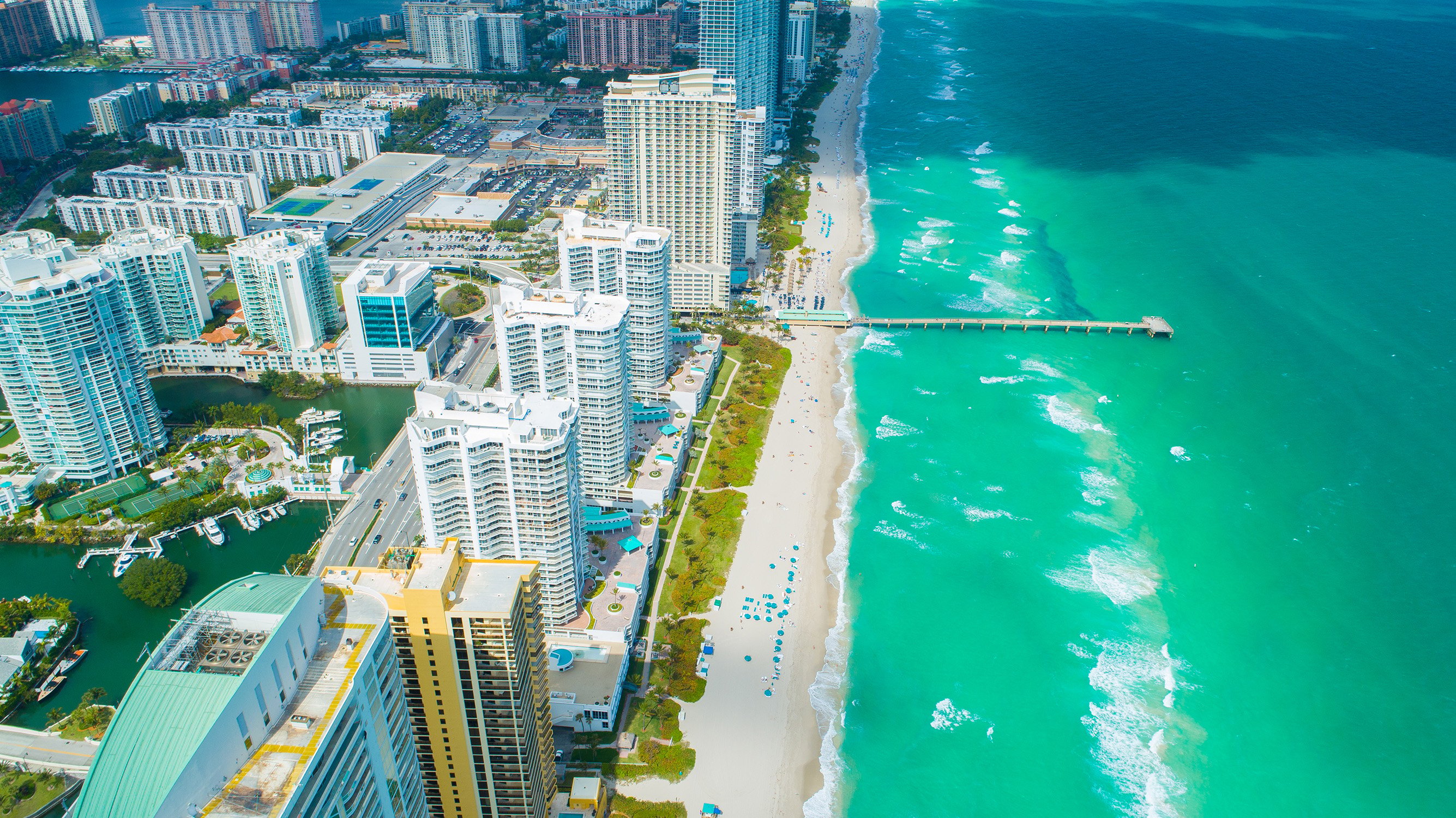 Sunny Isles Beach, Miami‑Dade coastal city view with sandy beach and piers, sought‑after zone for luxury and ultra luxury condos; preconstruction and resale.
