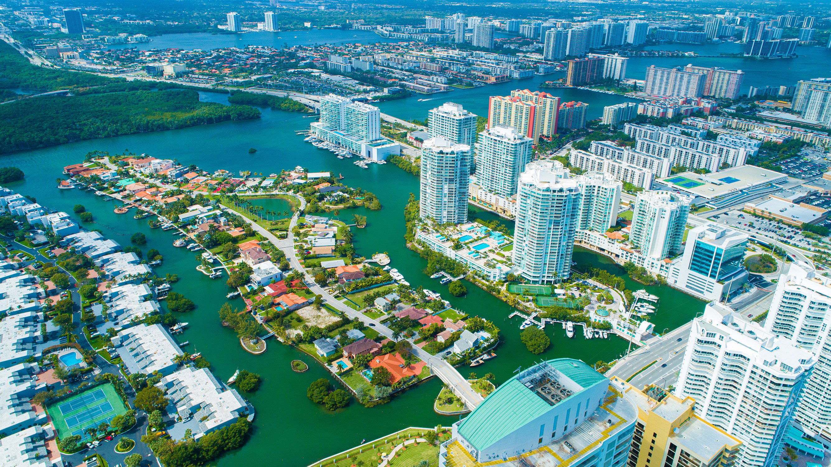 Sunny Isles Beach urban waterfront aerial, high‑rises along sandy shore, vibrant market for luxury and ultra luxury condos; preconstruction and resale. Featuring view.