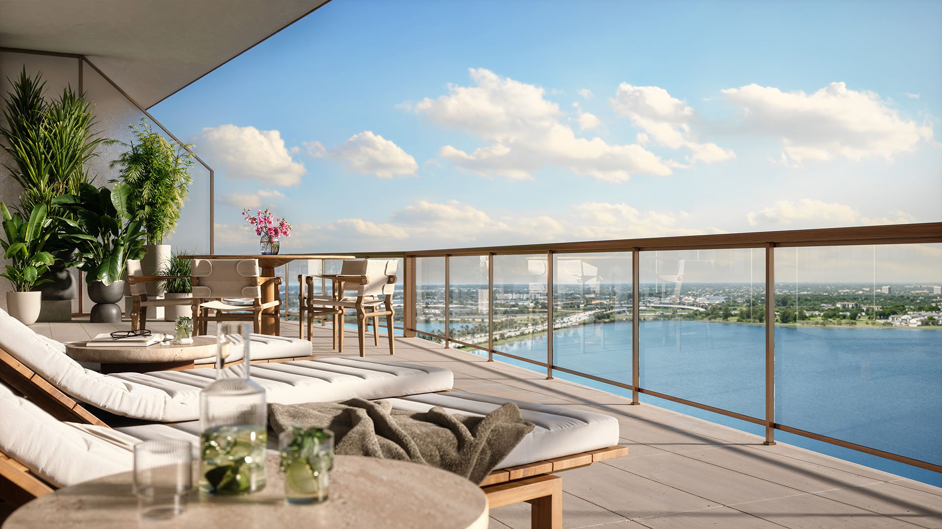 Covered waterfront terrace with loungers, dining seating, and a glass railing at The Berkeley in West Palm Beach, presenting luxury and ultra luxury condos with expansive outdoor entertaining space.