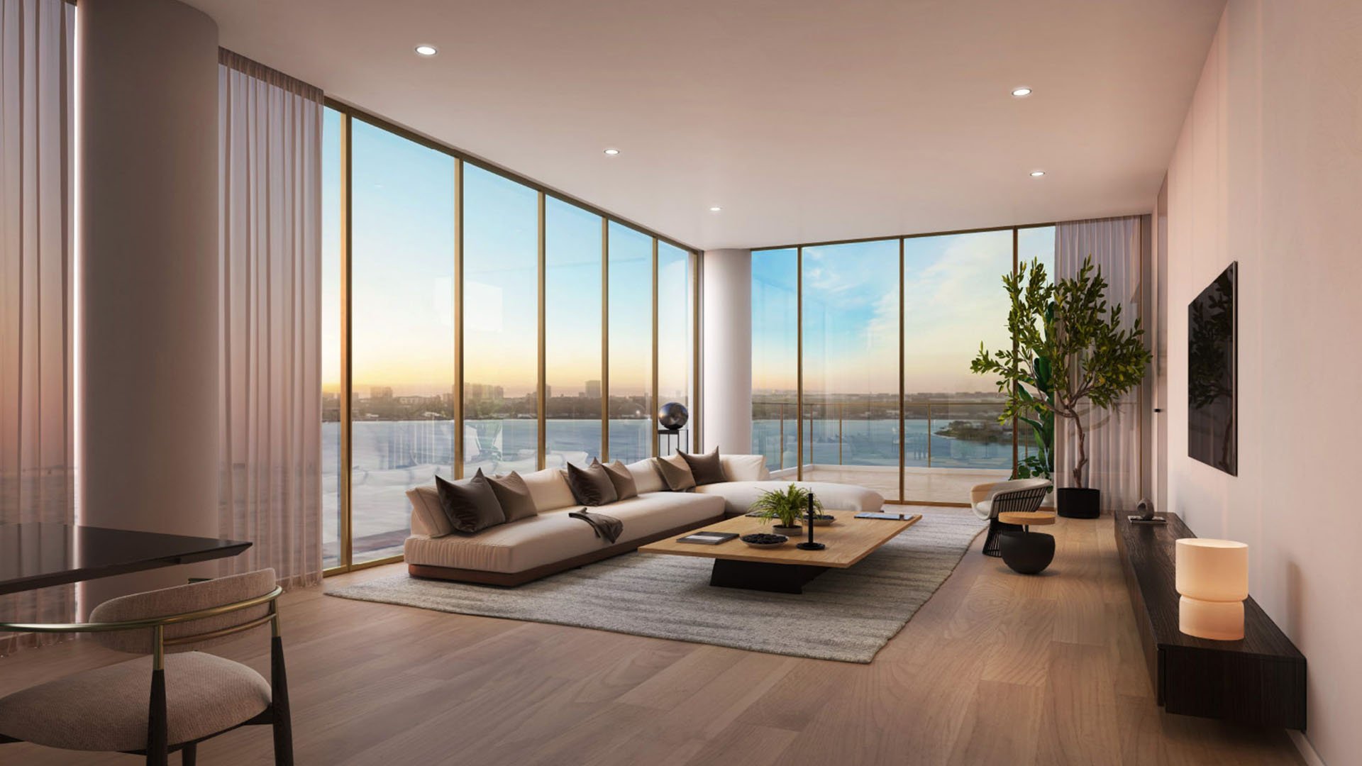 Minimal living room with a sectional sofa, corner glass, and sweeping water views at The Berkeley in West Palm Beach, presenting luxury and ultra luxury condos with calm contemporary interiors.