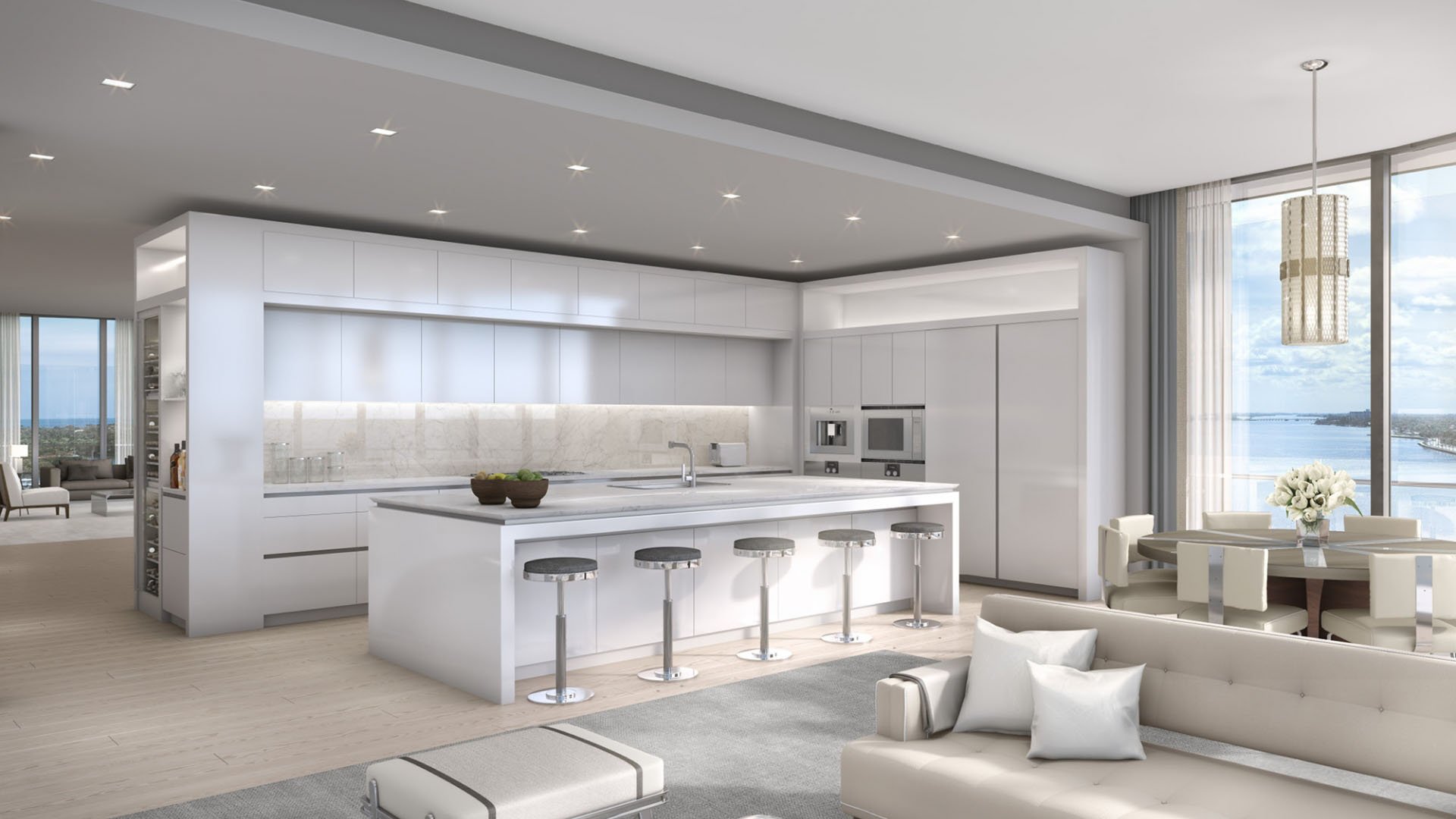 Open chef kitchen with an oversized island, custom cabinetry, and water views at The Bristol Palm Beach in Palm Beach, reflecting luxury and ultra luxury condos interior design.