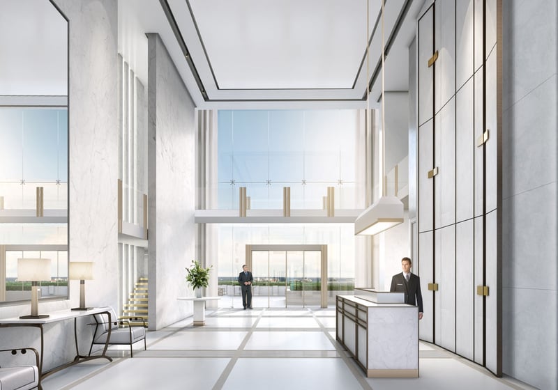 Double-height marble lobby with a reception desk and towering windows at The Bristol Palm Beach in Palm Beach, setting the tone for luxury and ultra luxury condos.