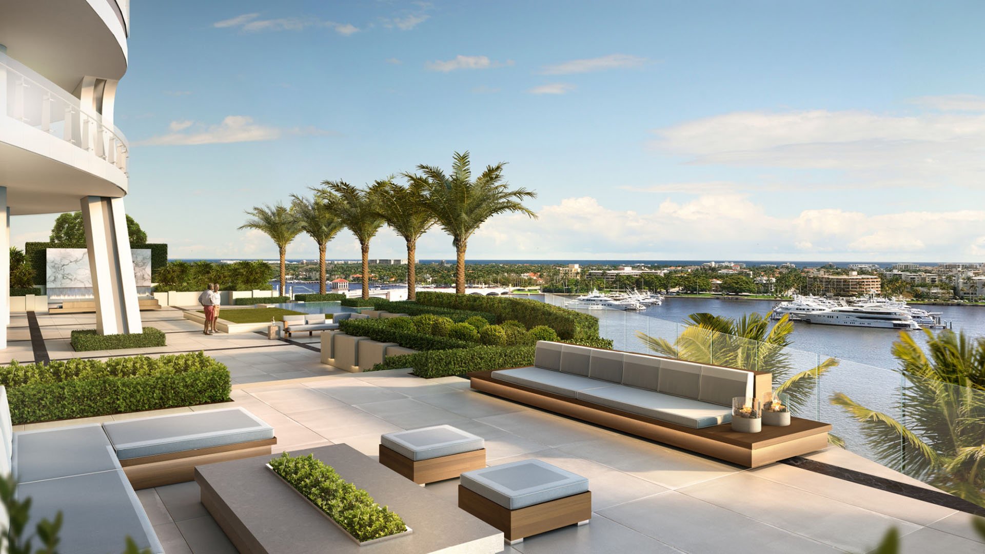 Palm-lined garden terrace with built-in lounge seating overlooking yachts and water at The Bristol Palm Beach in Palm Beach, extending the luxury and ultra luxury condos outdoor amenities.
