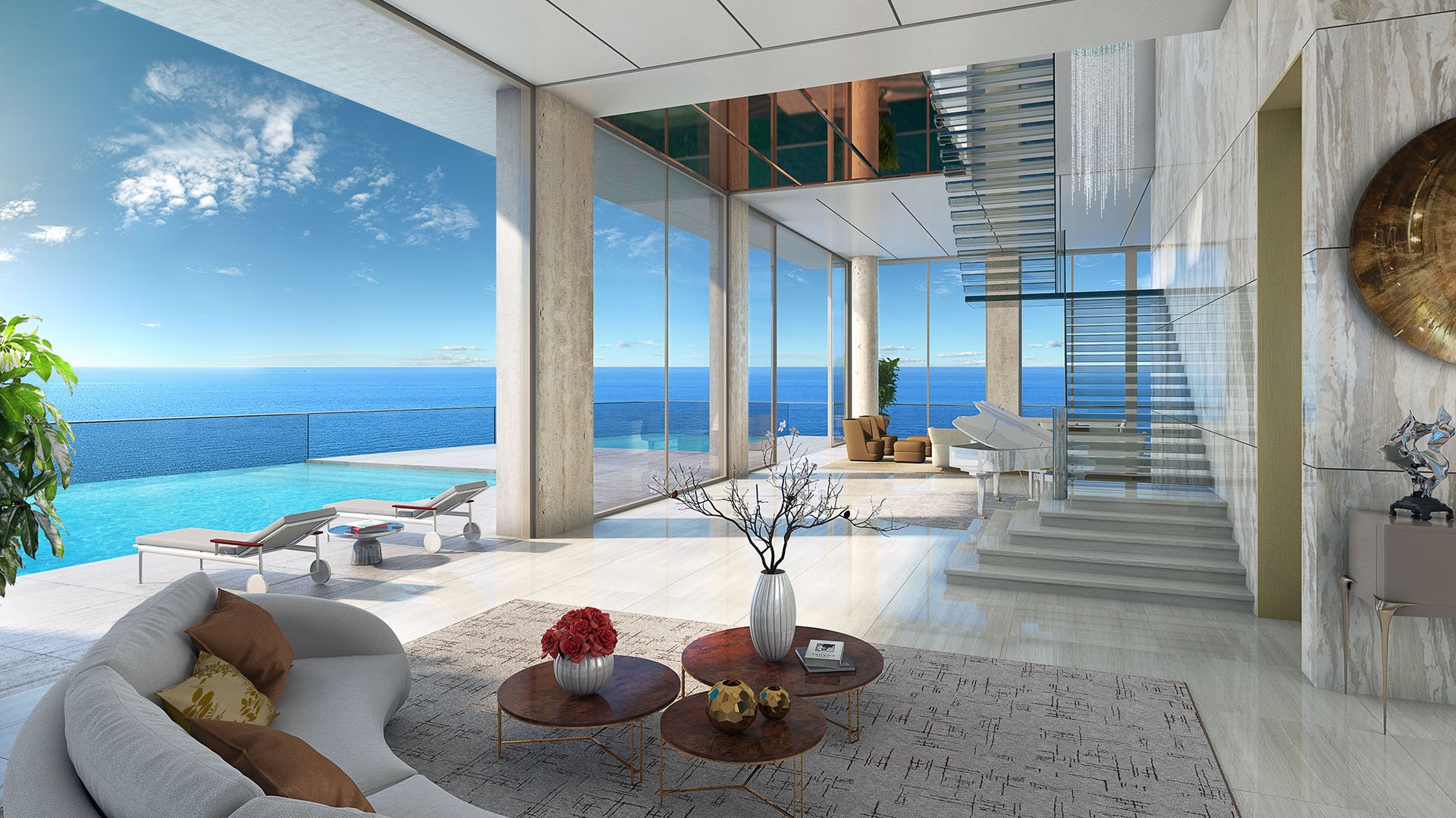 Double-height living room with a floating staircase and oceanfront terrace at The Estates at Acqualina, Sunny Isles Beach, a community of luxury and ultra luxury condos.