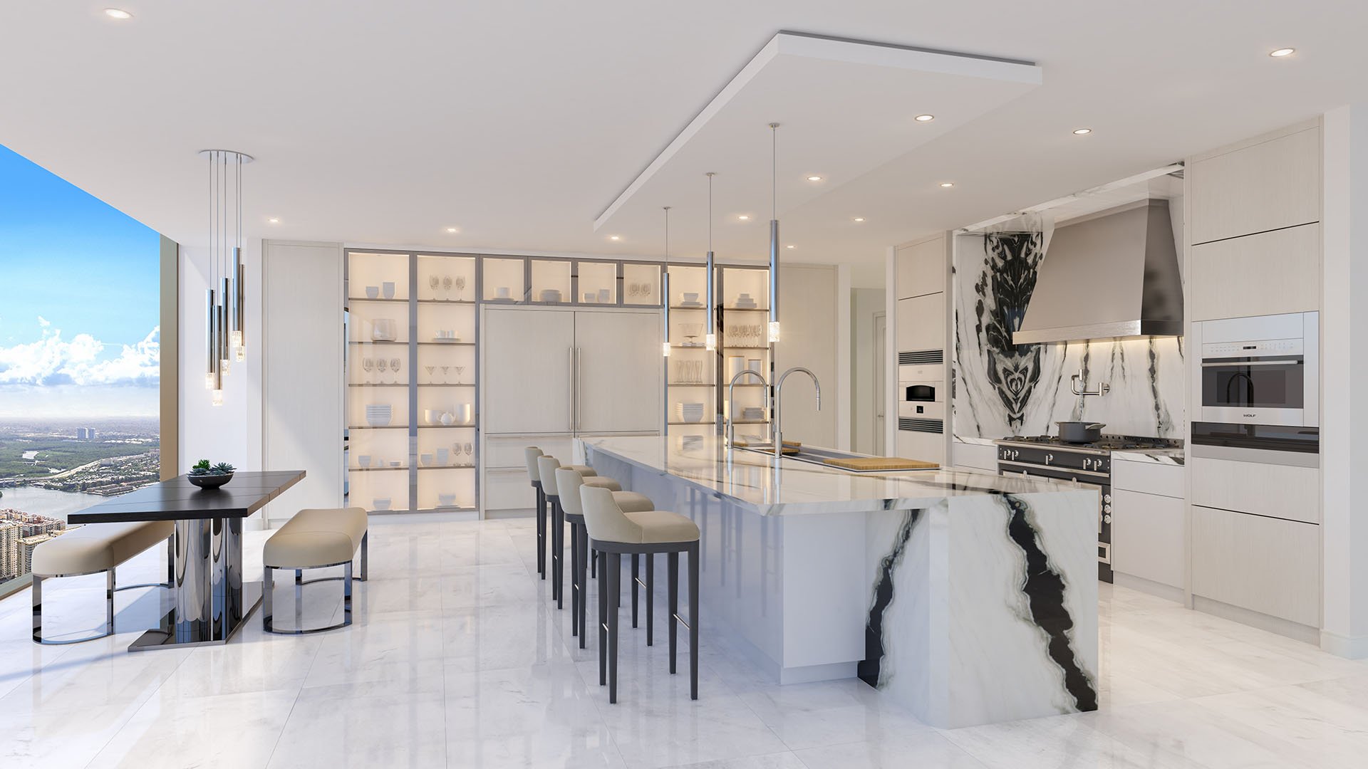 White chef kitchen with a marble waterfall island and skyline windows at The Estates at Acqualina, Sunny Isles Beach, a community of luxury and ultra luxury condos.
