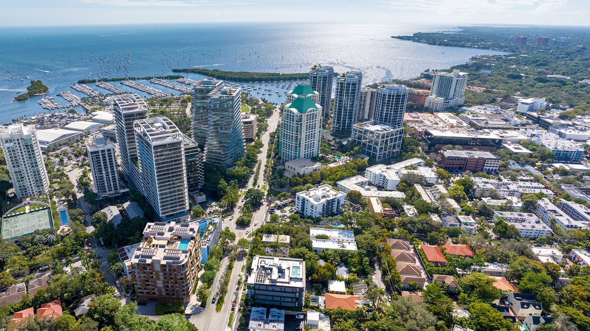 Aerial view of Coconut Grove, Miami, Florida and Biscayne Bay marinas with sailboats, near The Lincoln luxury and ultra luxury preconstruction condos, highlighting waterfront cityscape, yacht harbor and coastal lifestyle.