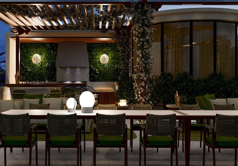 Night outdoor dining terrace at The Links Estates on Fisher Island, Miami Beach, Florida, with pergola, long table, outdoor kitchen grill and bar, curved glass pavilion, and ambient lighting - luxury and ultra luxury preconstruction condos.
