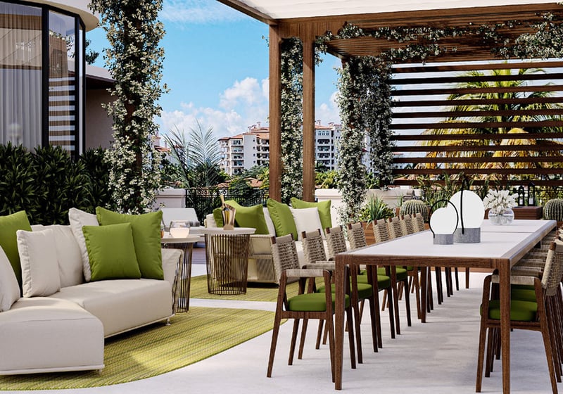 Day terrace dining and lounge at The Links Estates, Fisher Island, Miami Beach, Florida, showing pergola slat roof, long table, green cushions, and skyline views - luxury and ultra luxury preconstruction condos and villa outdoor living.