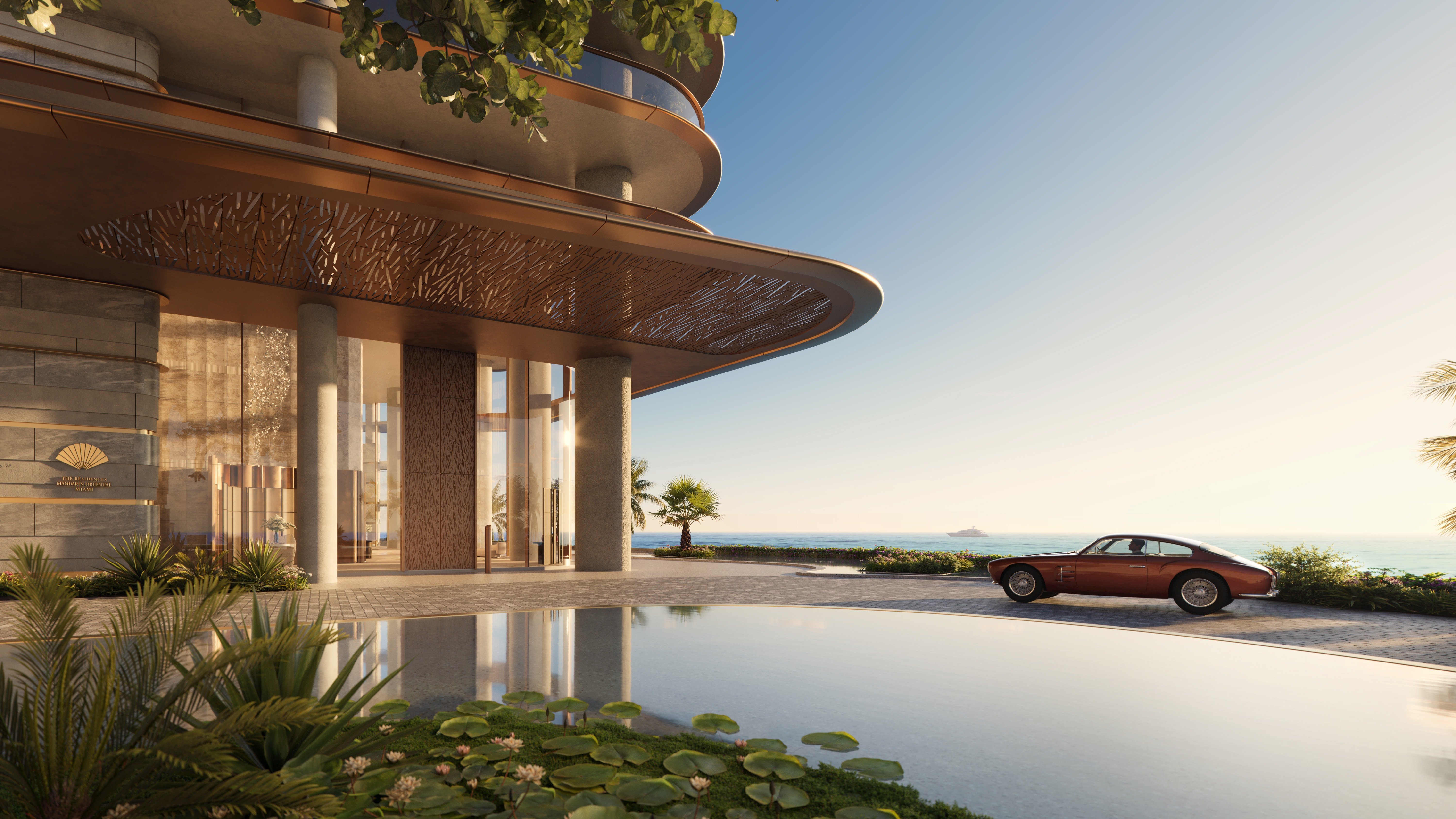 The Residences at Mandarin Oriental, Miami hotel‑style entrance with bay backdrop. Brickell Key; grand arrival for luxury and ultra luxury condos; preconstruction. Featuring ocean view.
