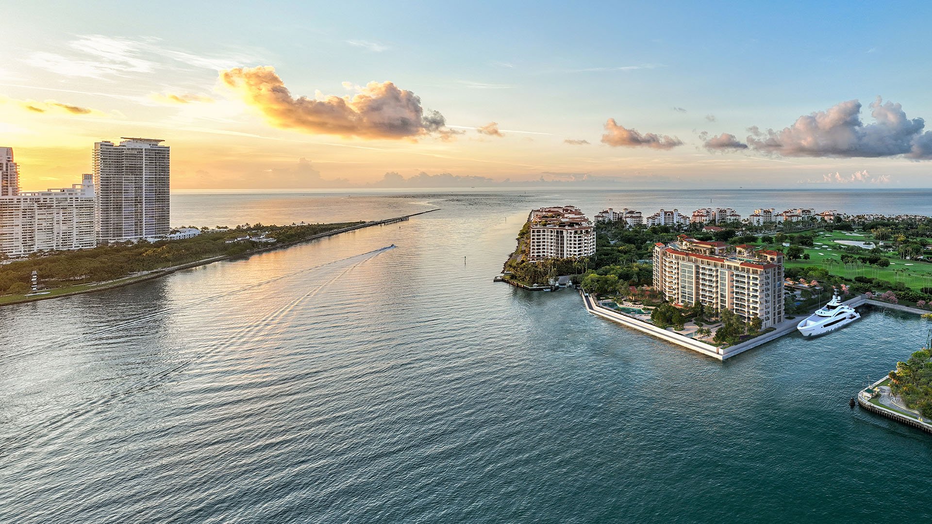 Aerial east view of The Residences at Six Fisher Island on Fisher Island, Miami Beach, Florida, overlooking Government Cut and South Pointe with private yacht dock and golf course, showcasing luxury and ultra luxury preconstruction condos.
