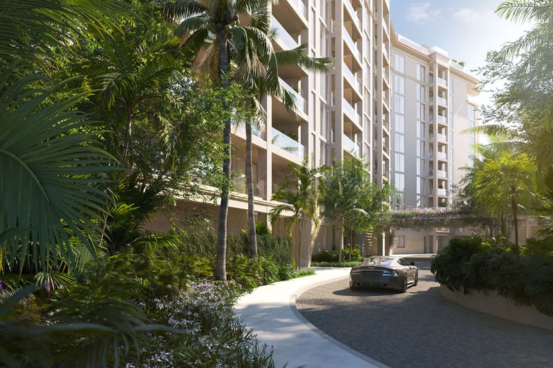 Tropical landscaped driveway approach to The Residences at Six Fisher Island on Fisher Island, Miami Beach, Florida, with palm-lined entry and modern facade, promoting luxury and ultra luxury preconstruction condos.
