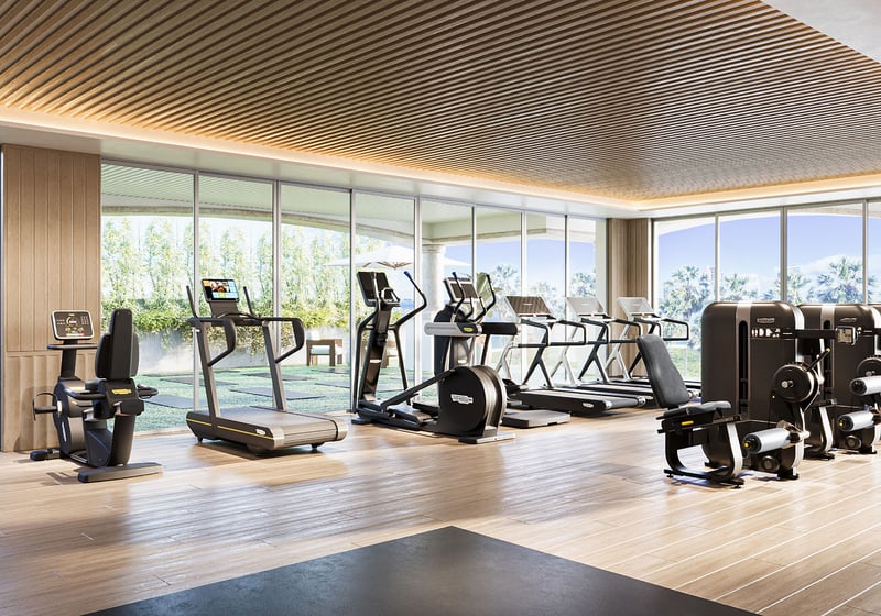 Fitness and yoga studio at The Residences at Six Fisher Island, Fisher Island Miami Beach, Florida, featuring treadmills and cardio equipment under a wood slat ceiling with ocean and bay views, part of luxury and ultra luxury preconstruction condos amenities.